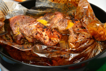 Roasted meat baked in the oven, knife and fork cutting roast.