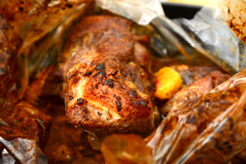 Roasted meat baked in the oven, knife and fork cutting roast.