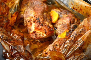 Fried juicy barbecue meat baked in the oven on a baking sheet.