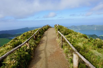 Obraz premium A thin hiking trail on top of the Boca Inferno Mountain in Sao Miguel, Azores overlooking sete cidades lakes