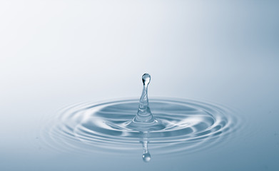 Water drop falling into water making a perfect droplet splash