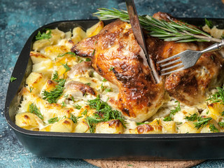 Baked chicken and cheese potatoes in cast iron. Close-Up