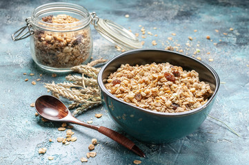 Homemade granola with nuts in a blue glass bowl. Morning light from the window.
