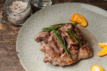 Roasted turkey meat with citrus and rosemary on a large gray plate