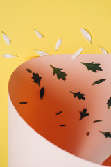 Creative pattern made of white petal and green leaves on pastel pink and light yellow background. Minimal concept, top view, flat lay