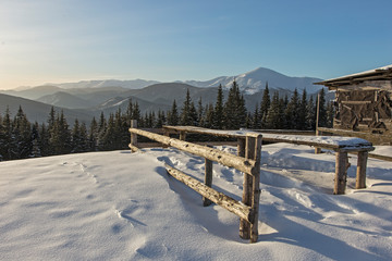 abandoned wooden hut in winter Carpathian mountains. shepherds' huts in the winter Carpathians on the background of snow-covered mountain ridges and coniferous forest. 