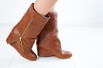 Side View Of Trendy Brown Leather Woman's Boots With Zipper On White Background