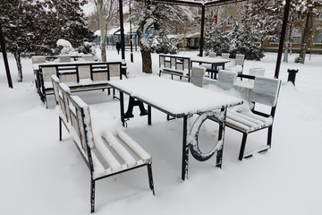 Tables and benches in snow.