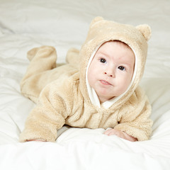  The baby is lying on a white bedspread