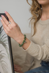 the girl has a jade bracelet, a green bracelet on arm, a jade bracelet on arm, a jewel on hand
