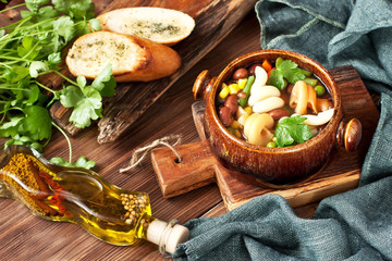 Minestrone, italian vegetable soup with pasta on wooden table