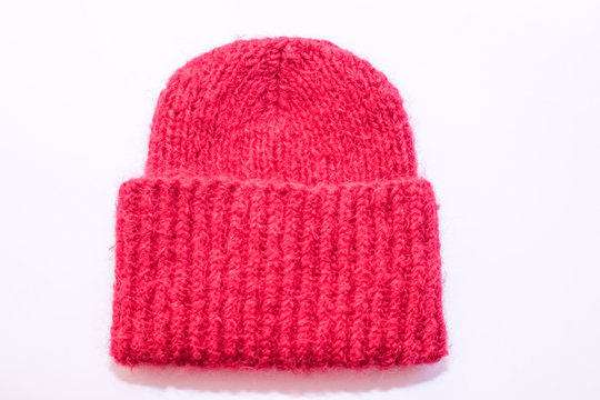 The bright pink knitted hat. White background.