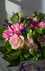 bouquet of flowers from pink gerberas, irises, lilies, roses in the hard sunlight