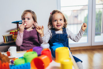 Children toddlers girls play toys at home, kindergarten or nursery.
