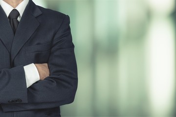 Confident business man wearing elegant suit with hands folded