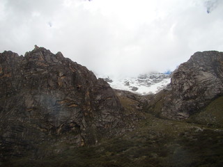 Andes mountain with snow at the top and cloudy sky with green valley at the bottom, Ancash province, Peru