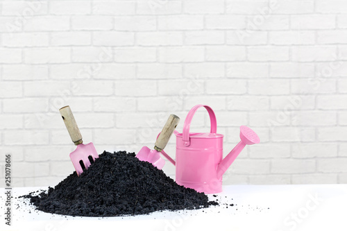 Pink Garden Tools And Watering Can With Compost Earth Pile The Pink Garden Tools And Watering Can With Compost Earth Pile The Trowel Fork Are