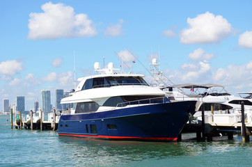Fototapeta na wymiar Blue and white motor yacht moored at a marina in Miami Beach,Florida