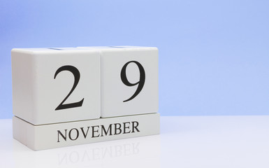 November 29st. Day 29 of month, daily calendar on white table with reflection, with light blue background. Autumn time, empty space for text
