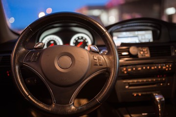 interior, steering wheel of a modern business car in the evening. backlight panel.