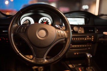 Fototapeta premium interior, steering wheel of a modern business car in the evening. backlight panel.