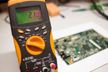 yellow modern multimeter with electrical board at the background 