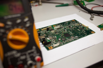 yellow modern multimeter with electrical board at the background 