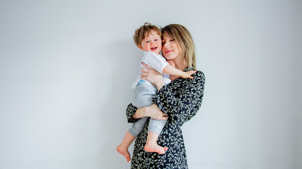Mother and son on a white wall background at home