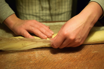 Confectioner at work with the dough. Hands close-up. Making cinnamon rolls. Traditional Swedish and Norwegian pastries.