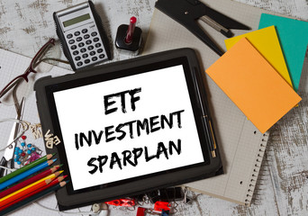 ETF Investment savings plans written on a board lying on a working space