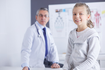 Obraz premium Portrait of a cute little girl and her doctor at hospital