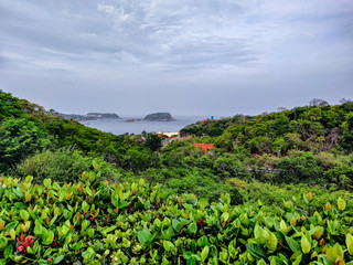 Fototapeta na wymiar Landscape overlook to the Pacific Ocean in Huatulco, Oaxaca. Travel in Mexico. Resort vacation.