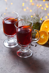 mulled red wine with spices and orange on dark background. warming drink