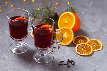mulled red wine with spices and orange on dark background. warming drink