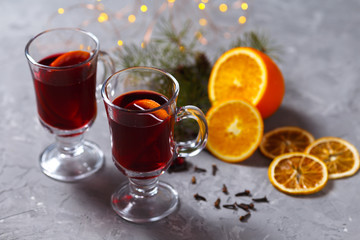 mulled red wine with spices and orange on dark background. warming drink