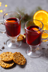 mulled red wine with spices and orange on dark background. warming drink