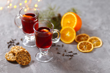 mulled red wine with spices and orange on dark background. warming drink
