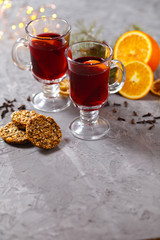 mulled red wine with spices and orange on dark background. warming drink