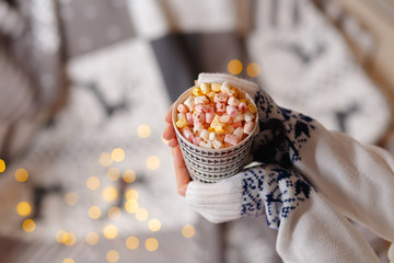 homemade hot chocolate with marshmallows in female hands.