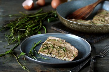 omelet with smilax (sarsaparilla) young shoots in the spring for nutrition. useful food from nature. young shoots are harvested in spring and eaten as asparagus. concept of nutrition from nature.