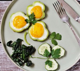 green breakfast on St. Patrick's Day. eggs in the form of clover. Fried Eggs Shamrock  in Green Pepper rings with Braised Spinach. parsley leaves like clover leaves.