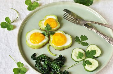 green breakfast on St. Patrick's Day. eggs in the form of clover. Fried Eggs Shamrock  in Green Pepper rings with Braised Spinach. parsley leaves like clover leaves.