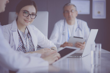 Serious medical team using a laptop in a bright office