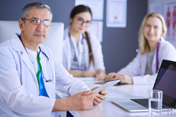 Fototapeta premium Doctor and patient discussing something while sitting at the table . Medicine and health care concept