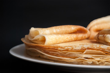 Pancakes, pancakes on a plate, dark background.