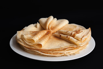 Pancakes, pancakes on a plate, dark background.