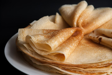 Pancakes, pancakes on a plate, dark background.