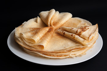 Pancakes, pancakes on a plate, dark background.