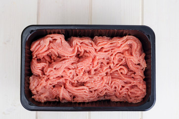 Minced meat in black plastic container