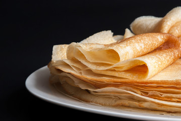 Pancakes, pancakes on a plate, dark background.